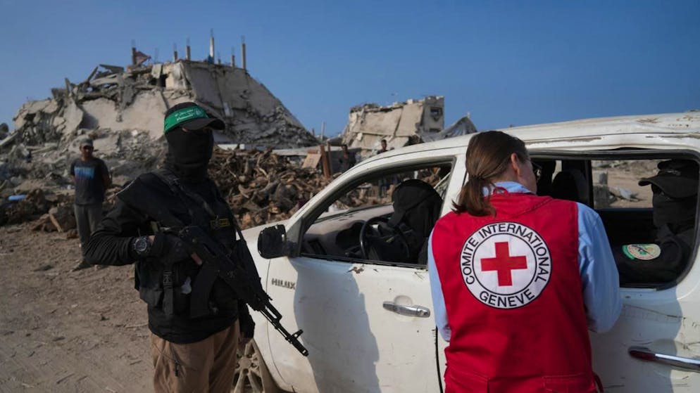 ARCHIV - Hamas-Kämpfer neben Mitgliedern des Internationalen Komitees vom Roten Kreuz (Archivbild). Foto: Jehad Alshrafi/AP/dpa