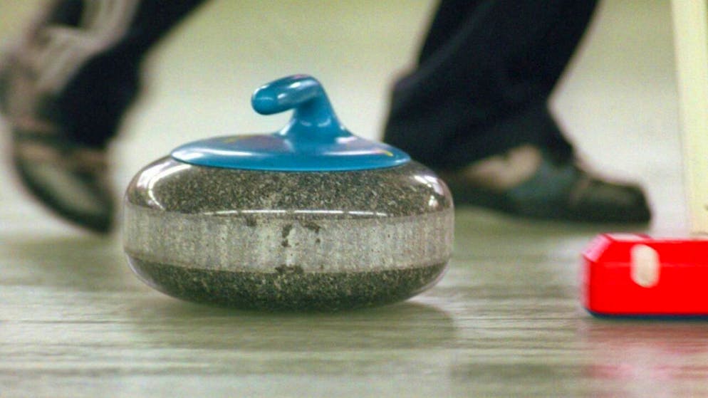 Der Curlingstein gleitet über das Eis