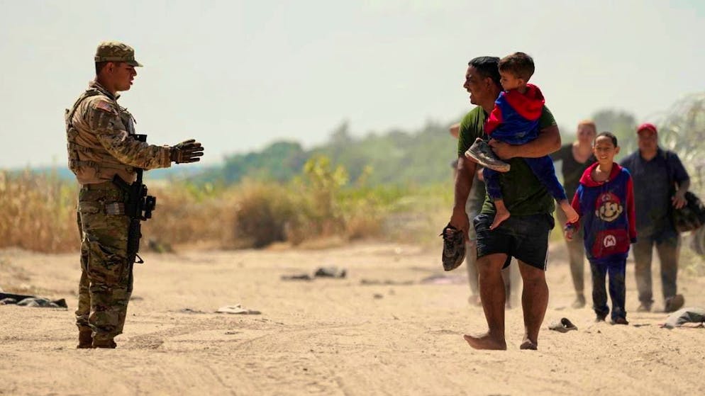 ARCHIVE - A security guard gives instructions to migrants who have crossed the Rio Grande in Mexico into the US. Photo: Eric Gay/AP/dpa