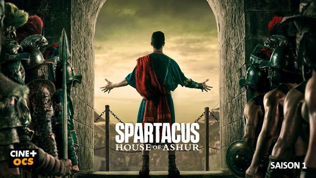 Eine Person in Gladiatorenkleidung steht mit ausgebreiteten Armen im Zentrum, blickt auf eine weite Landschaft und wird von kämpfbereiten Soldaten in voller Rüstung durch einen Torbogen flankiert, im Poster zur Serie Spartacus: House of Ashur.