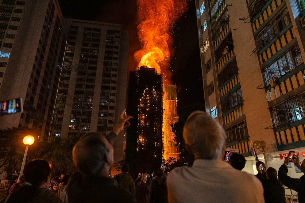 KEYPIX - People look at flames engulfing a building after a fire broke out at Wang Fuk Court, a residential estate in the Tai Po district of Hong Kong's New Territories, Wednesday, Nov. 26 2025. (AP Photo/Chan Long Hei)