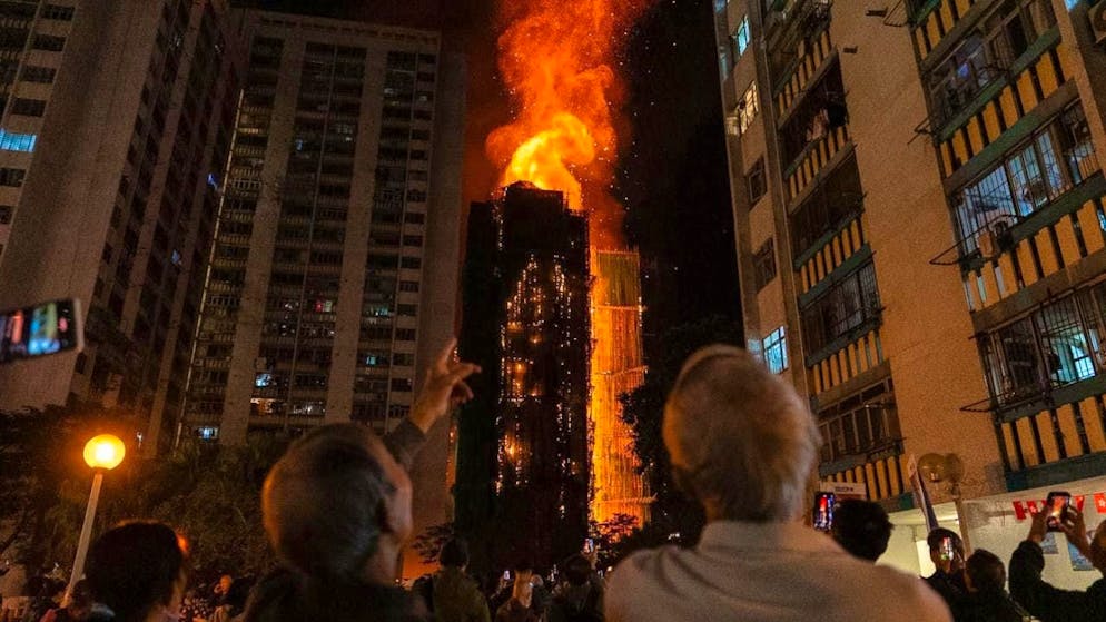 dpatop pictures - People look at the flames engulfing a building after a fire broke out in Wang Fuk Court, a housing estate in the Tai Po district of Hong Kong's New Territories. Photo: Chan Long Hei/AP/dpa