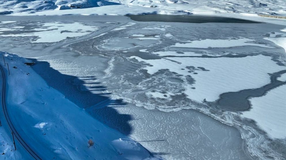 Il Lago Bianco sul Passo del Bernina è in parte ghiacciato. A sinistra si intravede la linea ferroviaria del Bernina da dove il macchinista ha intravisto gli oggetti sul lago appartenenti all'uomo deceduto.