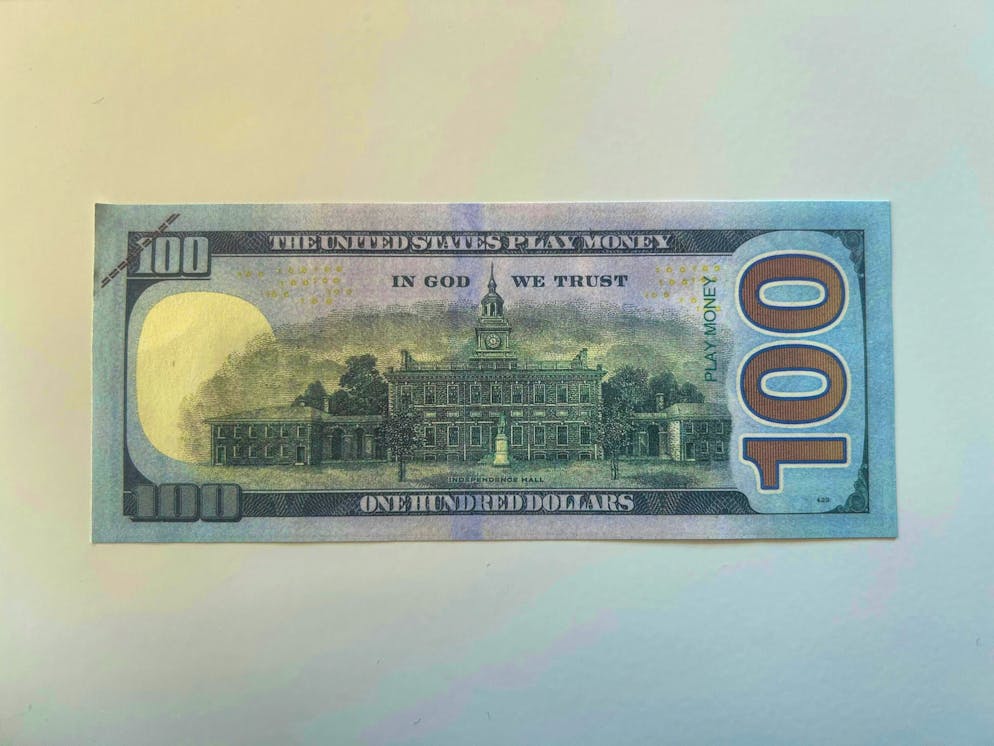 This is what forbidden counterfeit money looks like. On this 100-dollar note it says "Play Money" in small letters.