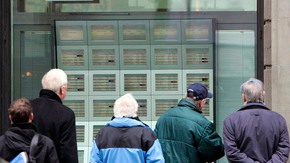 Passanti osservano l'andamento dello SMI sugli schermi di una filiale UBS alla Bahnhofstrasse di Zurigo (foto d'archivio).