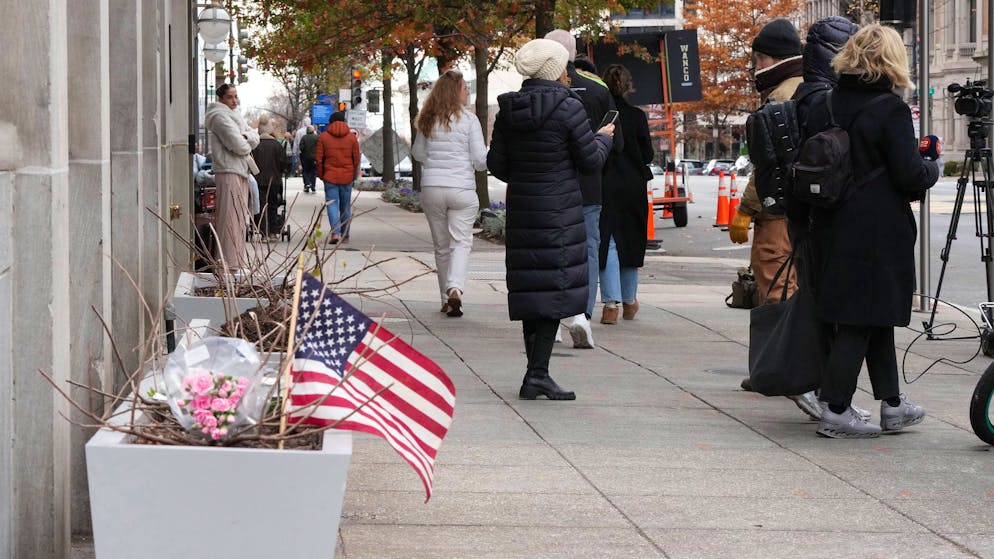 Blumen und eine amerikanische Flagge am Tatort in Washington. (27. November 2025)