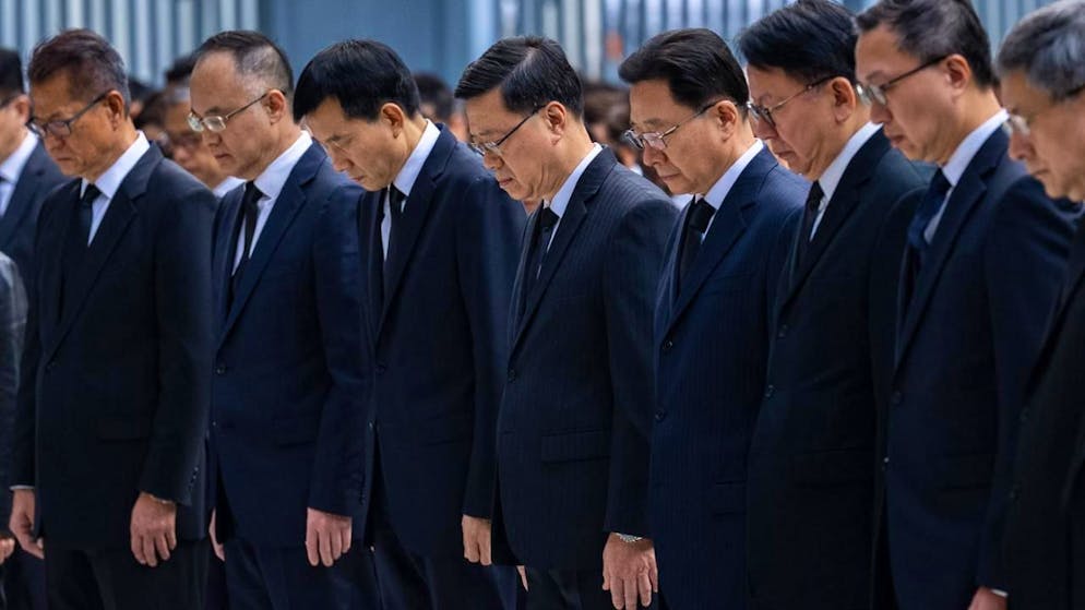 Hongkongs Regierungschef John Lee (Mitte) und führende Beamte der Sonderverwaltungszone legen eine Schweigeminute ein. Foto: Chan Long Hei/AP/dpa
