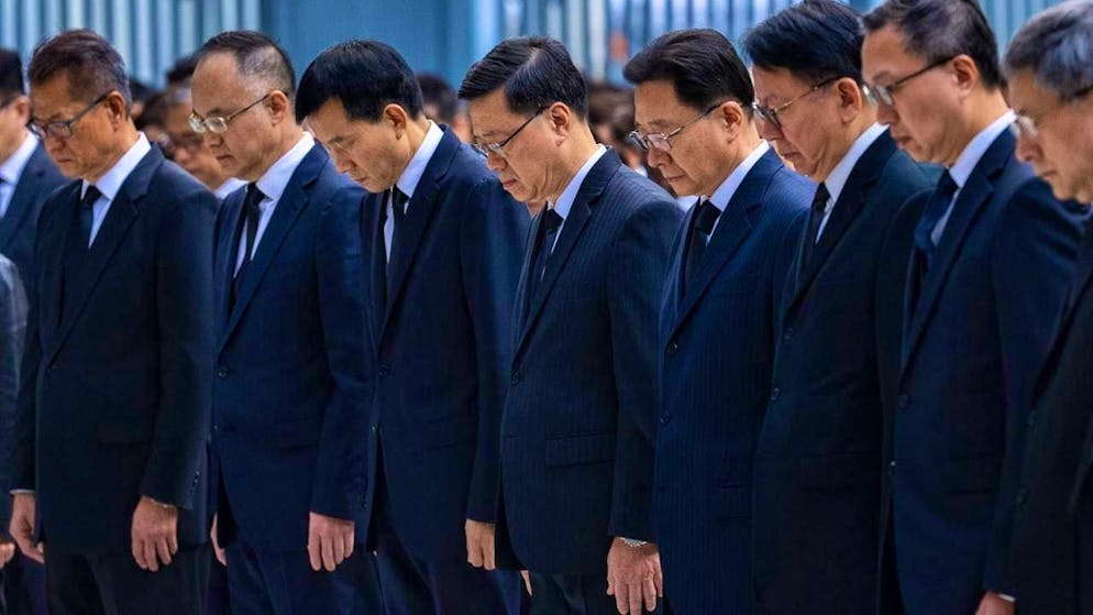 Hong Kong's Chief Executive John Lee (center) and leading officials of the Special Administrative Region observe a minute's silence. Photo: Chan Long Hei/AP/dpa