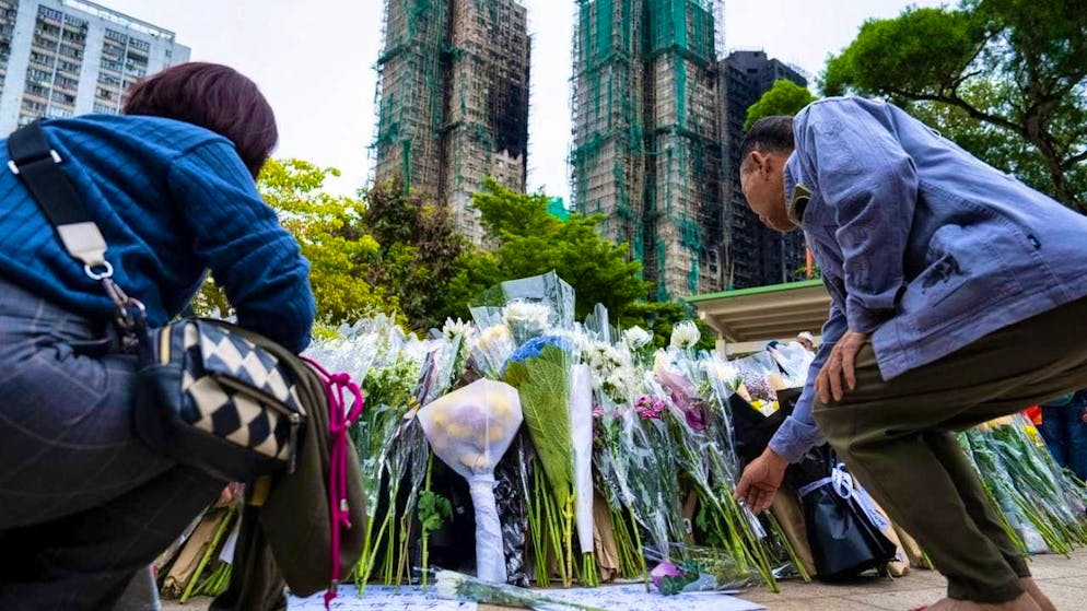 People lay flowers for the victims of the deadly fire at Wang Fuk Court. Photo: Chan Long Hei/AP/dpa