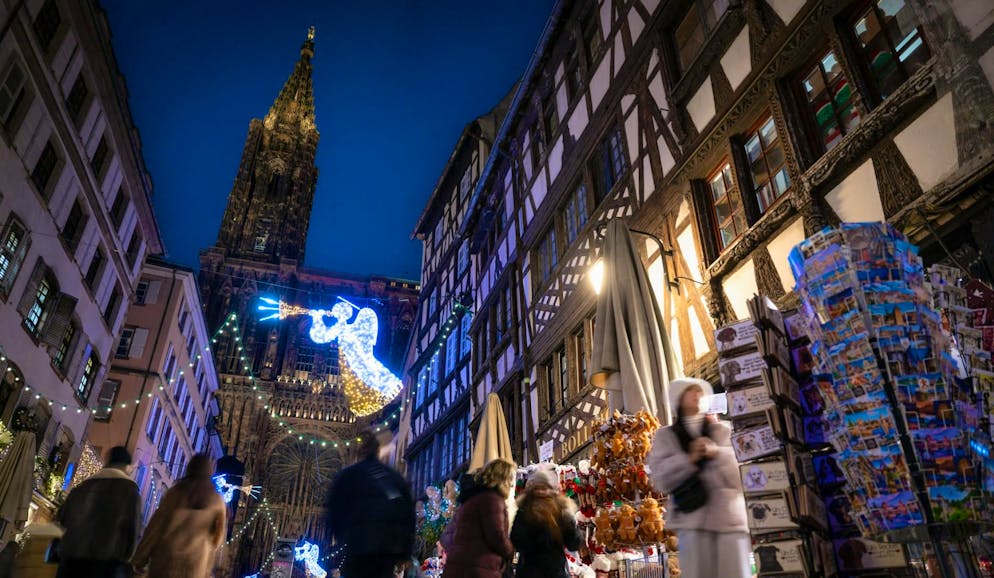 Surtourism. I passanti passeggiano in una strada di fronte alla cattedrale di Strasburgo, nella Francia orientale, durante il tradizionale mercatino di Natale. Kaysersberg e Riquewihr sono tra i villaggi turistici più popolari della regione, con quasi 4 milioni di persone che hanno visitato i mercatini nel 2024.