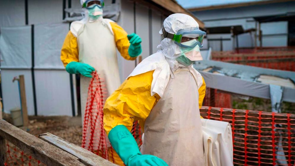 ARCHIV - Helfer kommen in Schutzanzügen zu ihrer Schicht in einem Behandlungszentrum mit Ebola-Erkrankten. Foto: Jerome Delay/AP/dpa