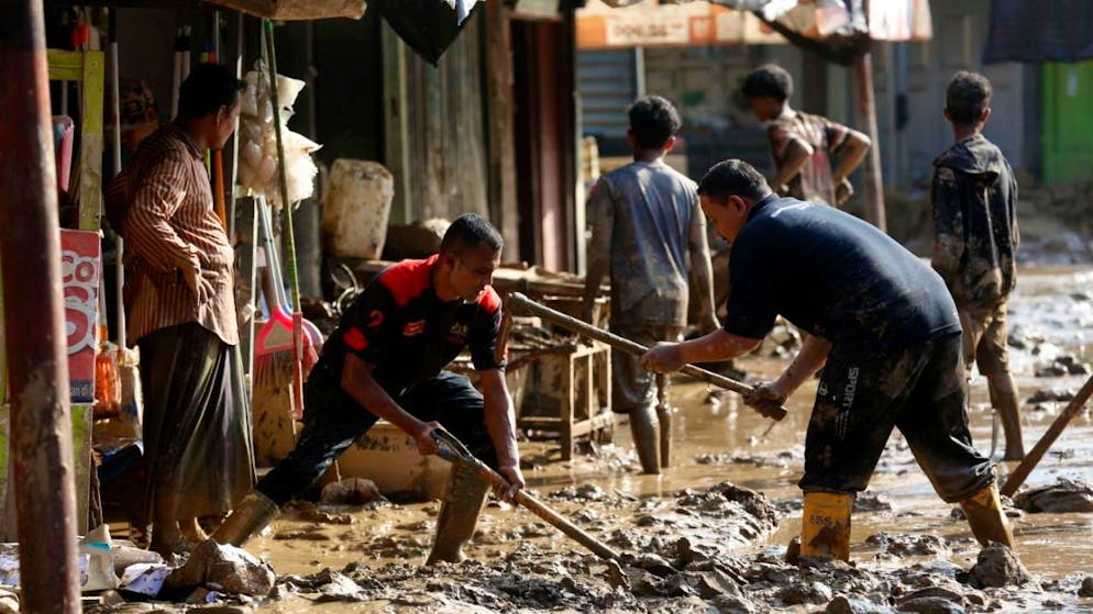 Les habitants d'un village de la région de Meureudu nettoient les rues après le passage du Cyclone Senyar.