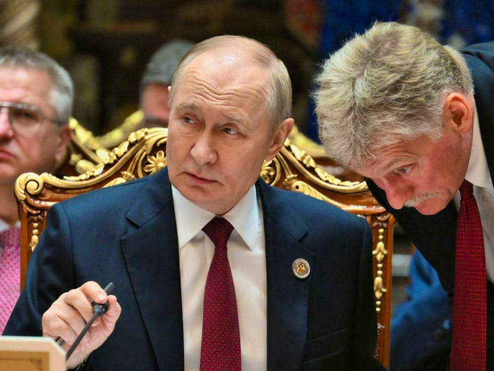 Russian President Vladimir Putin (l) and Kremlin spokesman Dmitry Peskov.