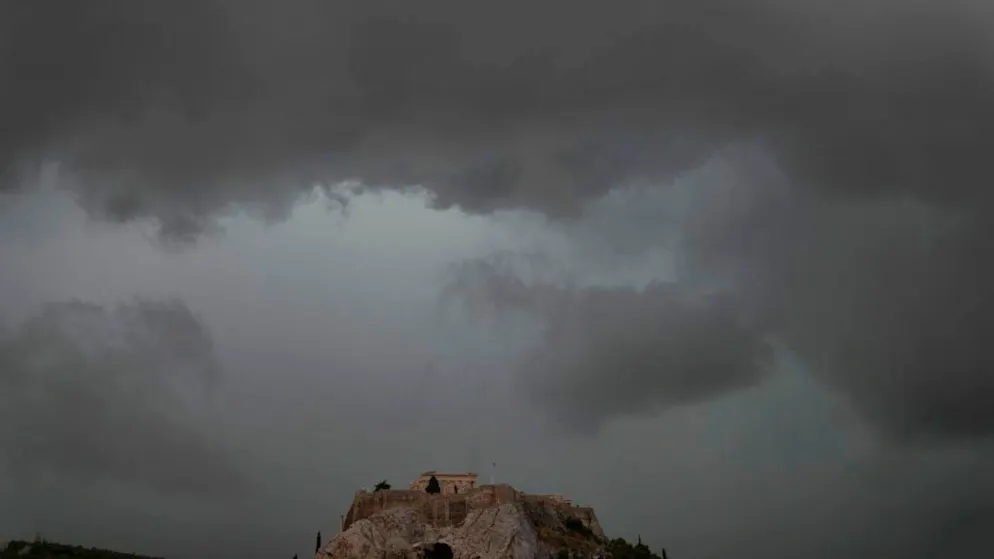 ARCHIV - Graue Wolken bedecken den Himmel über dem Akropolis-Hügel während eines Regenschauers. Foto: Thanassis Stavrakis/AP/dpa