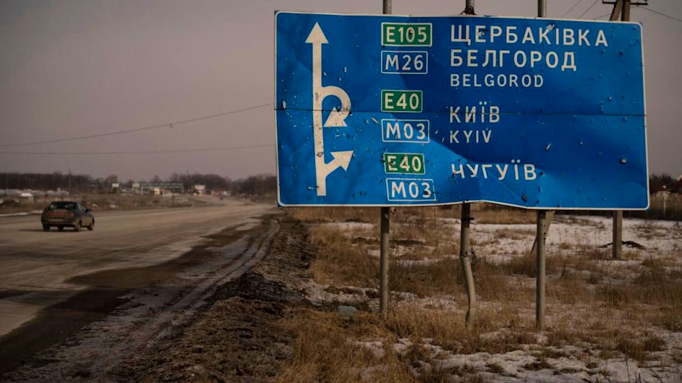 ARCHIV - Ein Auto fährt an einem von Kugeln und Granatsplittern beschädigten Straßenschild auf der Straße zur russischen Stadt Belgorod vorbei. Foto: Vadim Ghirda/AP/dpa/Symbolbild