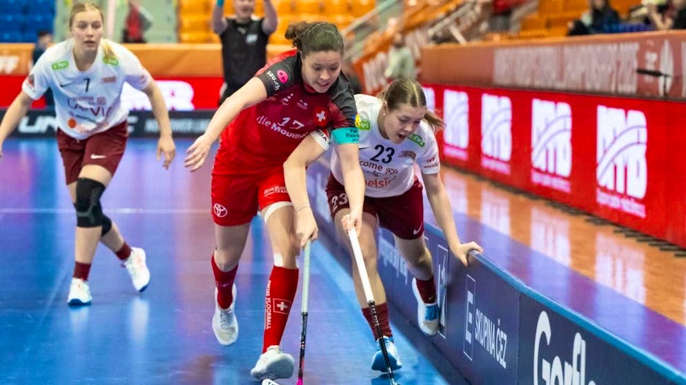 Isabelle Gerig (in red) runs the ball away from Latvia's Emilija Nico Salaciete (number 23)