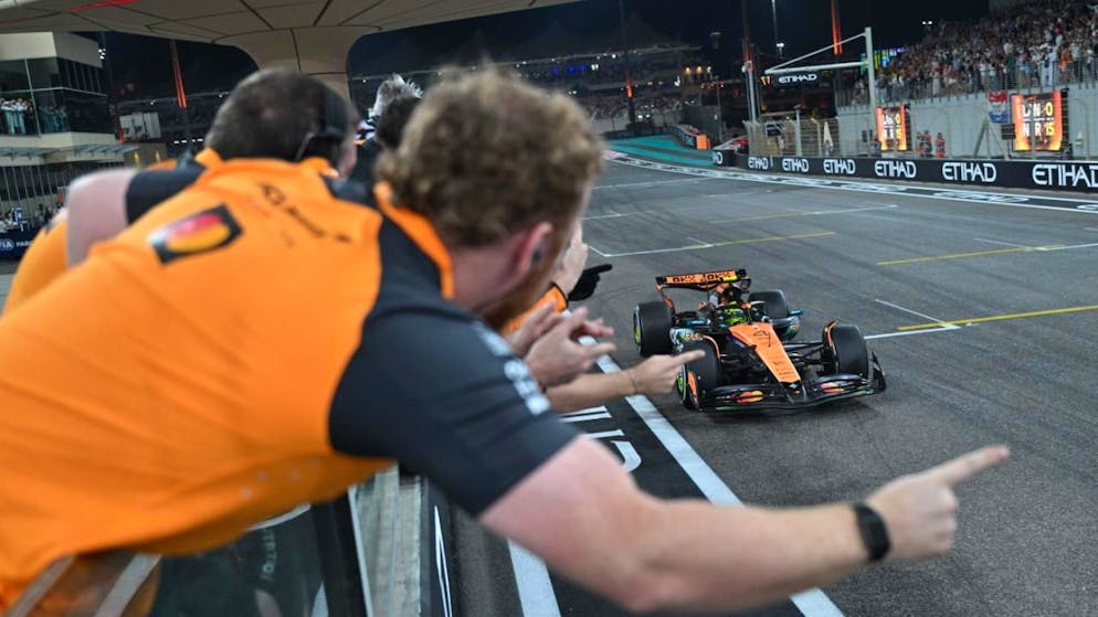 Lando Norris passiert die Ziellinie vor den Augen seiner McLaren-Mechaniker in Abu Dhabi als Dritter und ist damit erstmals Formel-1-Weltmeister