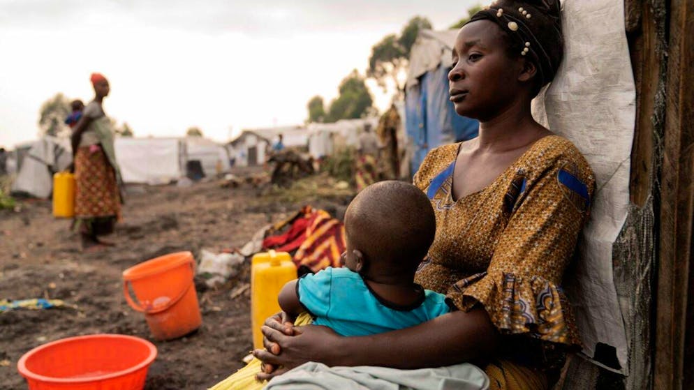 ARCHIV - Eine Mutter mit ihrem Kind sitzt vor ihrem Zelt in einem Flüchtlingslager im Kongo. Foto: Moses Sawasawa/AP/dpa/Symbolbild