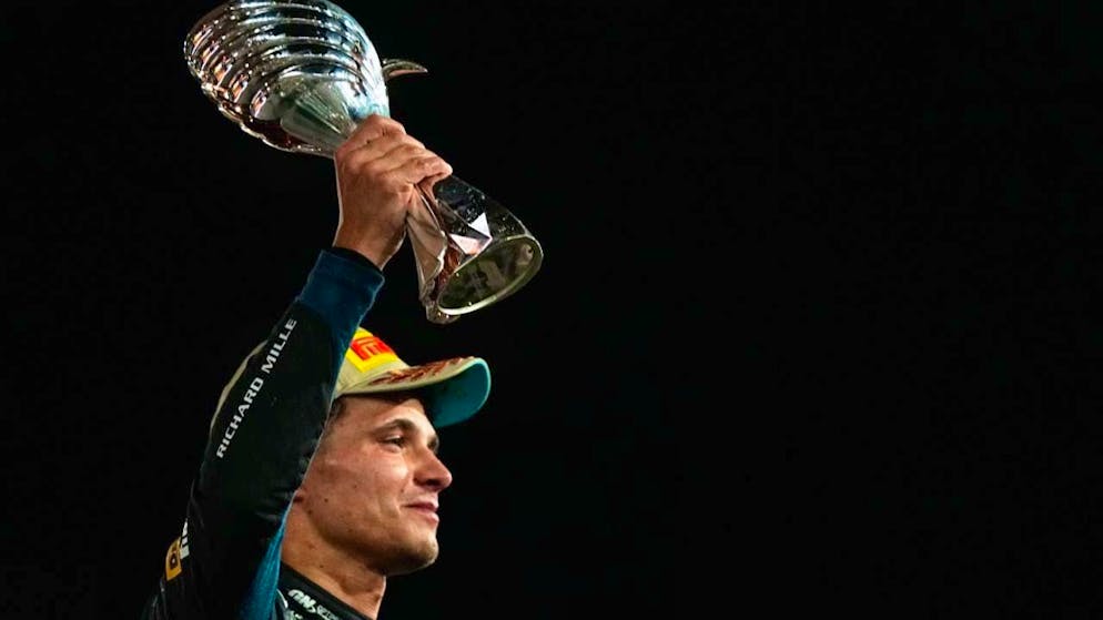 Lando Norris celebrates with the world championship trophy