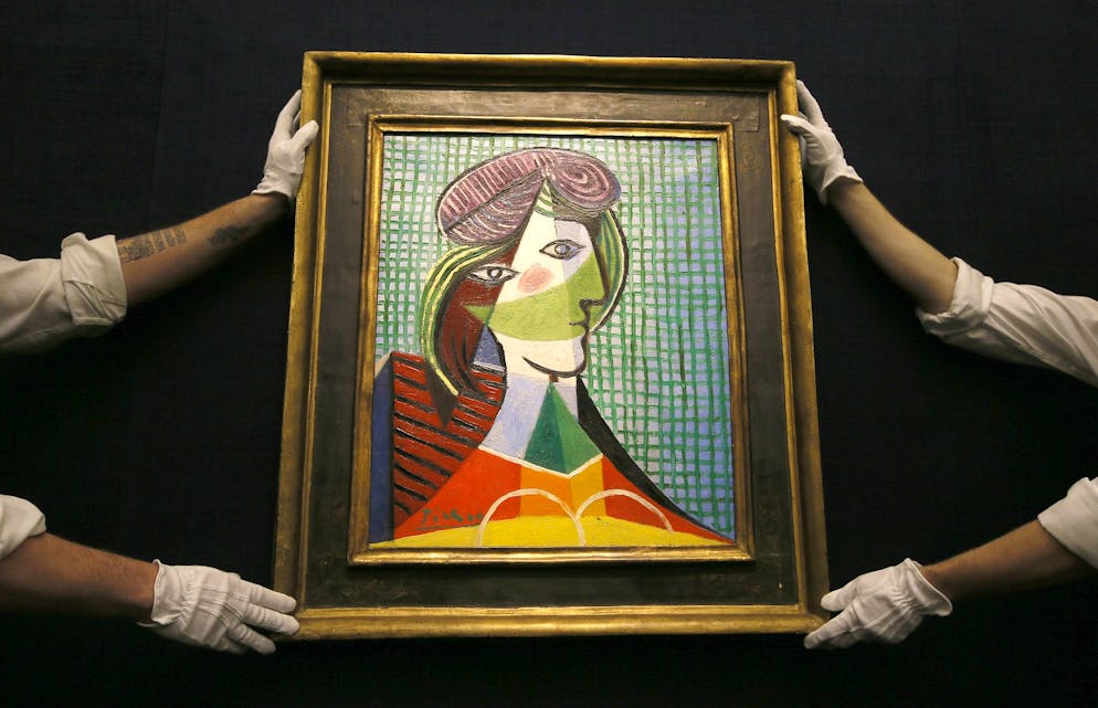 Sotheby's employees adjust a painting by Pablo Picasso called 'Tete de Femme' at the auction rooms in London, Thursday, Jan. 28, 2016. The painting is estimated at 16-20 million pounds (US$23-29 million) when it goes up for auction in London on Feb. 3. in the Impressionist and Modern Art Evening Sale. (AP Photo/Kirsty Wigglesworth)