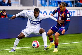 Nicky Beloko (LS), gauche, lutte pour le ballon avec Kevin Rueegg (FCB), droite, lors de la rencontre de football de Super League entre FC Lausanne-Sport et FC Basel 1893 le dimanche 26 octobre 2025 au stade de la Tuiliere a Lausanne. (KEYSTONE/Jean-Christophe Bott)