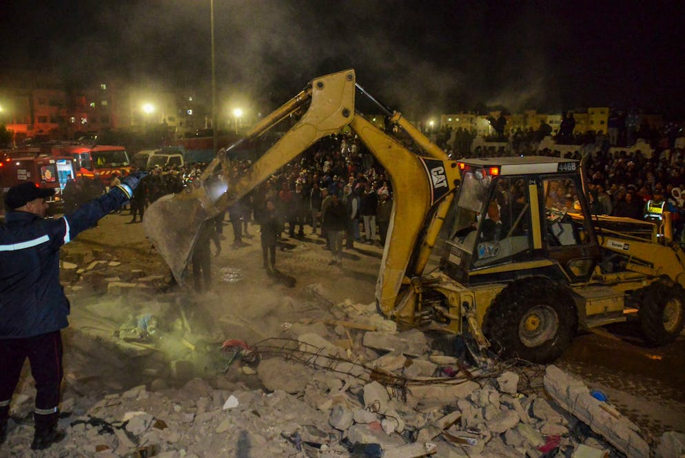 Rescue workers and residents search for survivors amid the wreckage of two collapsed buildings in Fez, Morocco, Tuesday, Dec. 9, 2025. (AP Photo/Ahmed Alaoui Mrani)