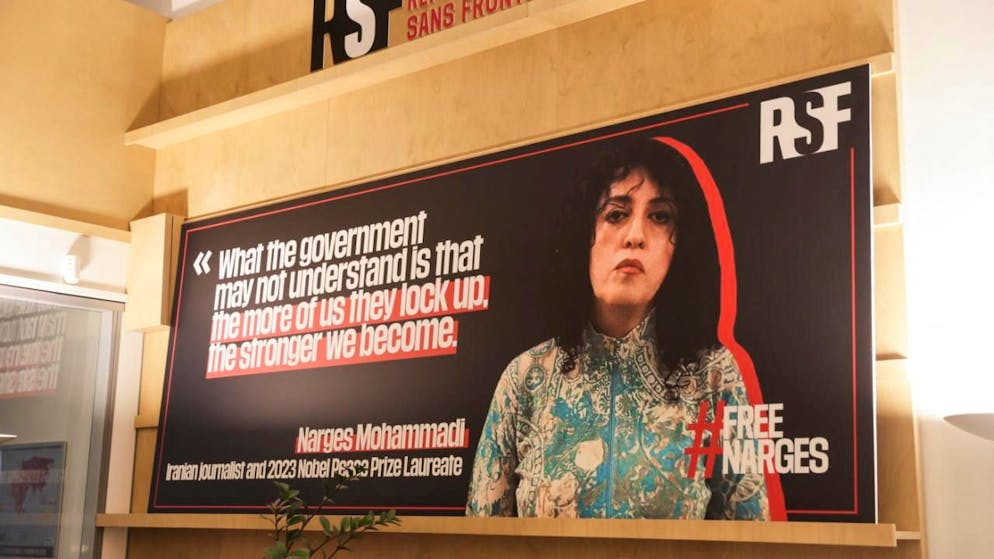 La giornalista ed attivista iraniana Narges Mohammadi, su un manifesto di Reporters sans Frontières (RSF)  a Parigi. (immagine d'archivio)
