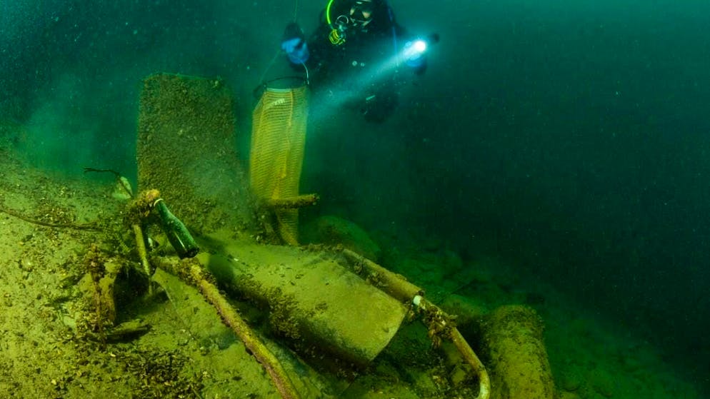 Dozens of divers clear litter from the right bank of Lake Thun - Gallery. Divers put waste from Lake Thun into collection nets to bring the contents ashore.