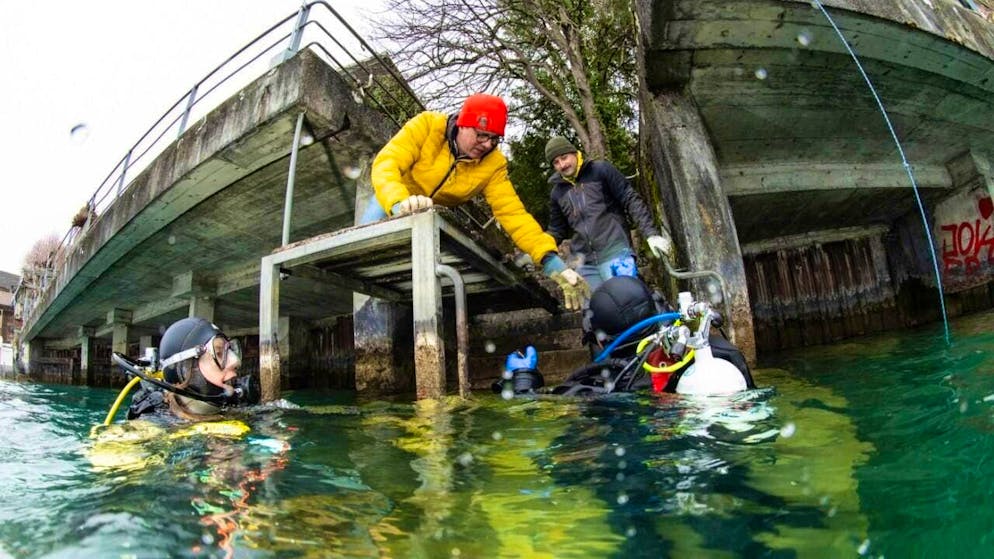 Dozens of divers clear litter from the right bank of Lake Thun - Gallery. Divers bring litter ashore from the lake in Gunten on Saturday.
