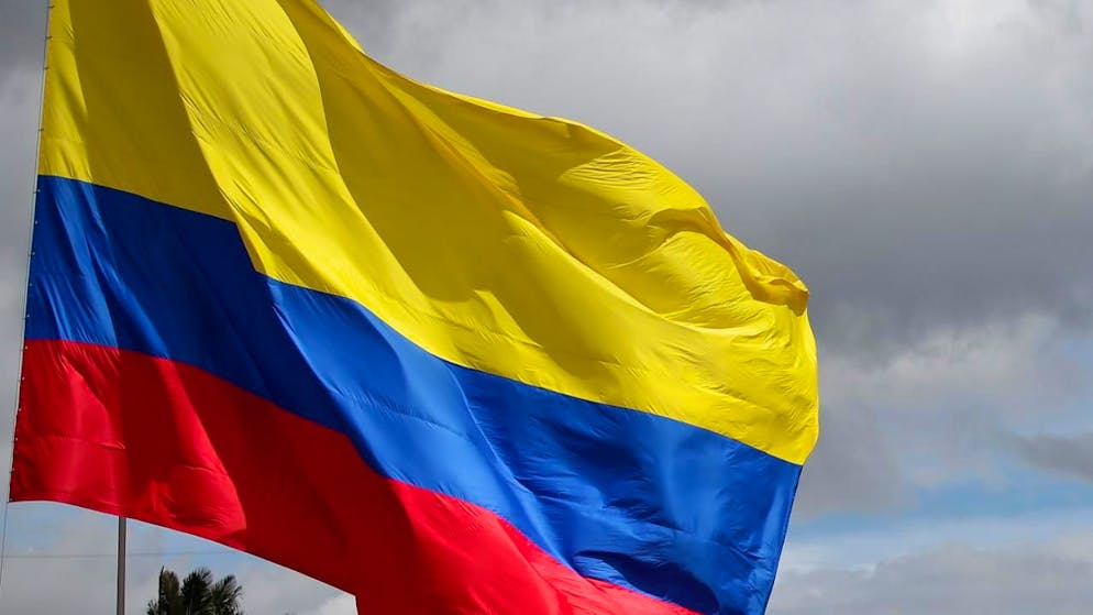 ARCHIV - Eine kolumbianische Fahne weht am «Tag der Helden», bei einer Militärparade in Bogota. In Kolumbien hat es ein schweres Busunglück mit mehreren Toten gegeben. Foto: Luisa González/colprensa/dpa