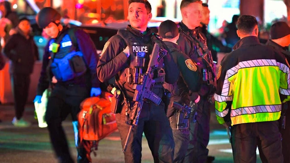 Law enforcement officials carrying weapons gather near Brown University after shots were fired. Photo: Steven Senne/AP/dpa