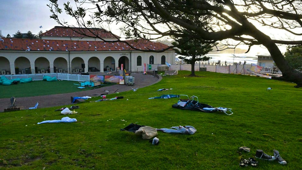 Chairs, bath towels and other items that people left behind as they fled bullets on Sunday lie on a lawn near Bondi Beach.