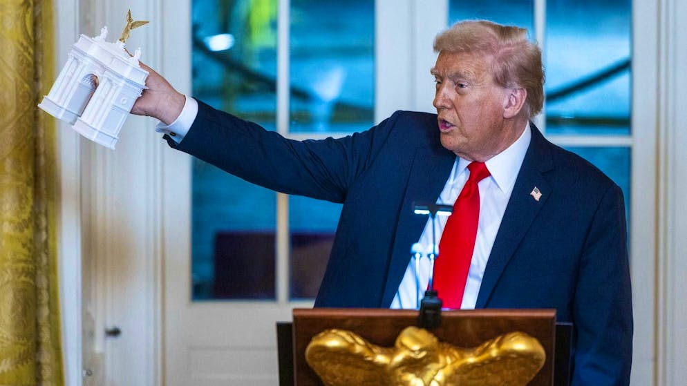 Donald Trump with a model of the Arc de Triomphe he wants at the White House on October 15.