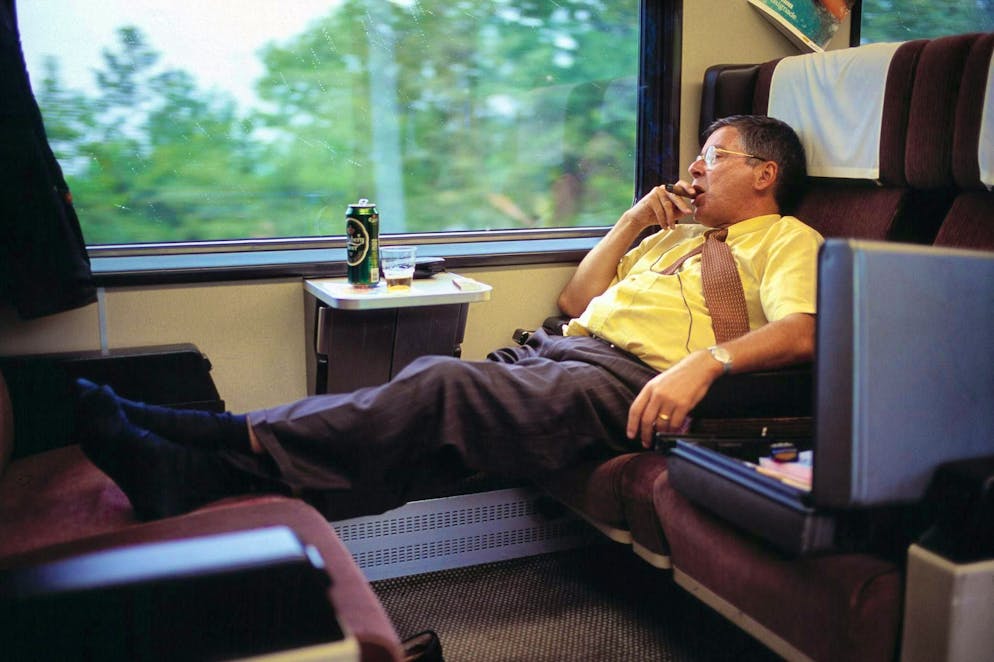 Da 20 anni è vietato fumare sui treni delle FFS. Gambe alzate, birra e poi una sigaretta, o meglio un sigaro in treno, come in questa foto del 2003 sulla linea Schuepfheim-Konolfingen. Oggi è impensabile.