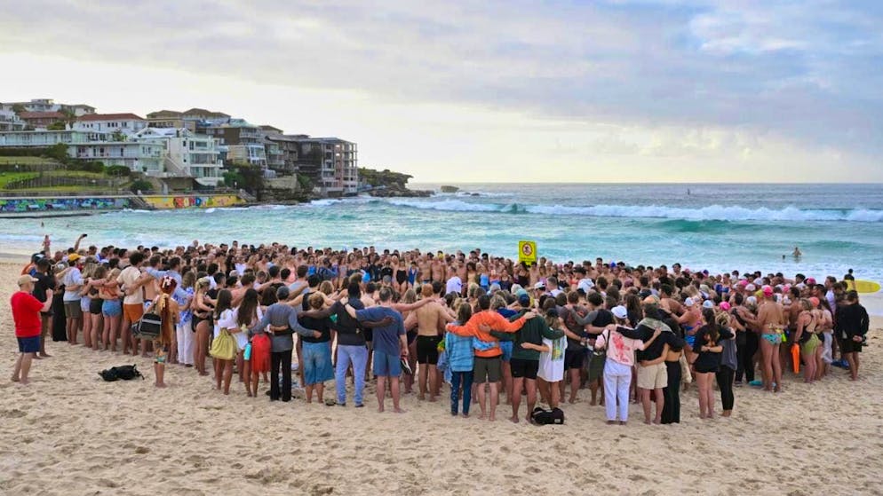 Swimmers gather for a vigil on the beach to remember the victims of the attack at Bondi Beach. Photo: Mick Tsikas/AAP via AP/dpa