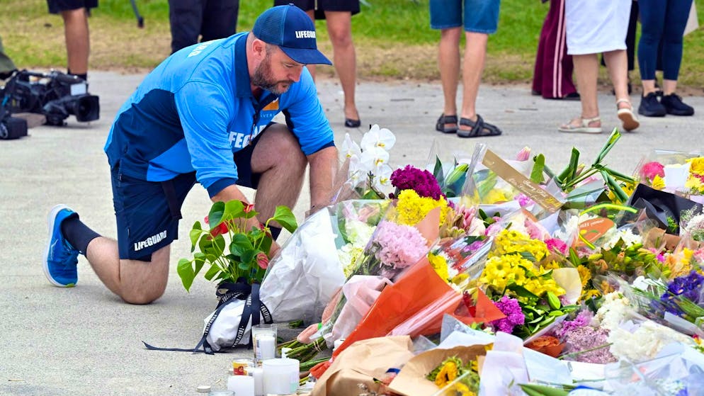 A lifeguard lays flowers at Bondi Beach. (December 16, 2025)