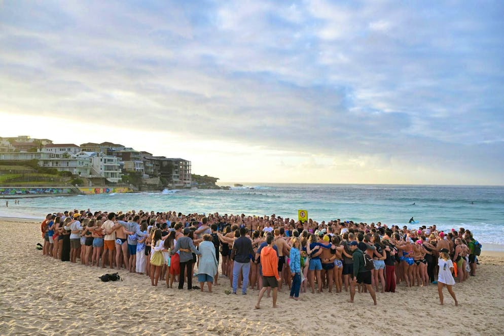 Swimmers from various swimming and surfing clubs take part in a vigil in Sydney on Tuesday.