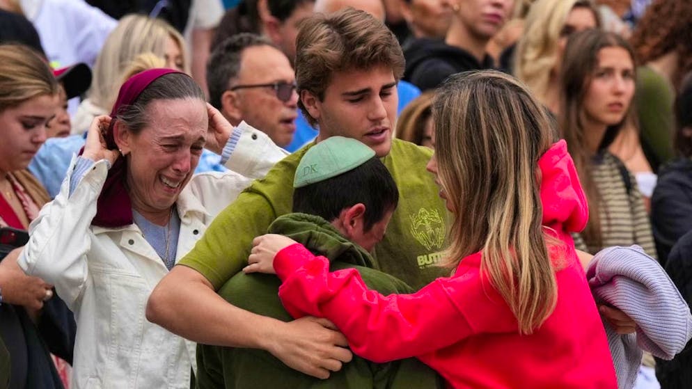 Family members of a victim of Sunday's shooting mourn at a floral memorial erected after the attack at Bondi Pavilion on Bondi Beach in Sydney, Australia. Photo: Mark Baker/AP/dpa