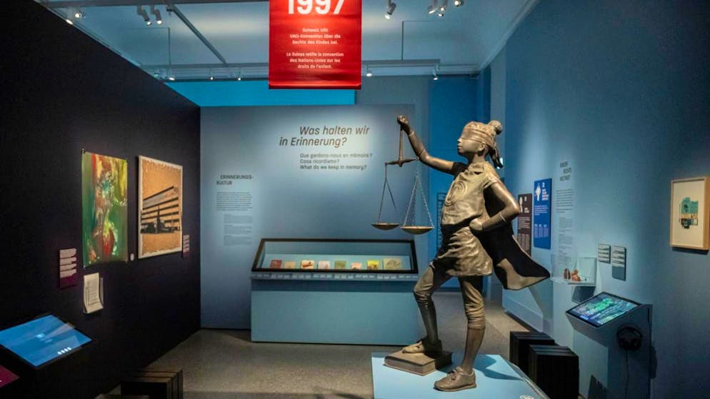 L'histoire du travail des enfants en Suisse expliquée à Zurich - Gallery. Dans la dernière partie de l'exposition, le public peut se plonger dans la réalité actuelle du travail des enfants. Une statue de la Justice vêtue d’une cape de Superman y rappelle la Convention des Nations Unies relative aux droits de l’enfant, ratifiée par la Suisse en 1997.