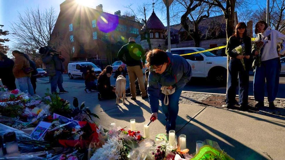 A woman lights a candle at a memorial erected in front of the Barus and Holley Engineering Building at Brown University in Providence. Police are using photos and video to search for a second man for questioning after a fatal shooting at the elite university in the US state of Rhode Island. Photo: Mark Stockwell/FR171920 AP/AP/dpa