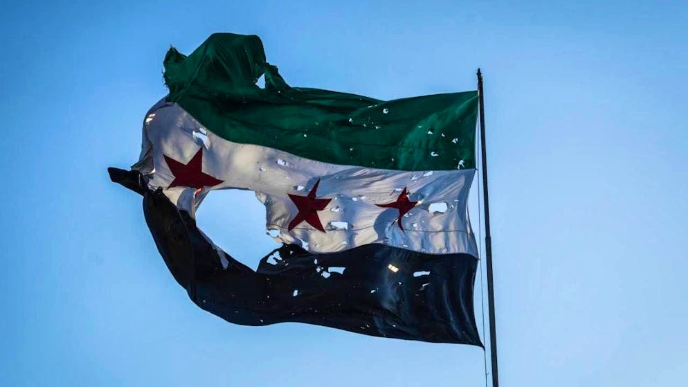ARCHIVE - A tattered Syrian flag flies in front of the Syrian General Staff headquarters. Photo: Moawia Atrash/dpa/symbol image