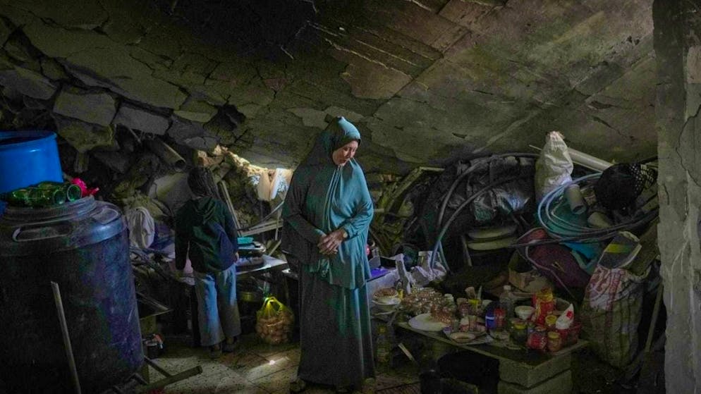 Khadija Abu Shaqfa and her daughter Rita walk through the kitchen of their damaged house, where food and pottery lie amidst the rubble. Photo: Jehad Alshrafi/AP/dpa