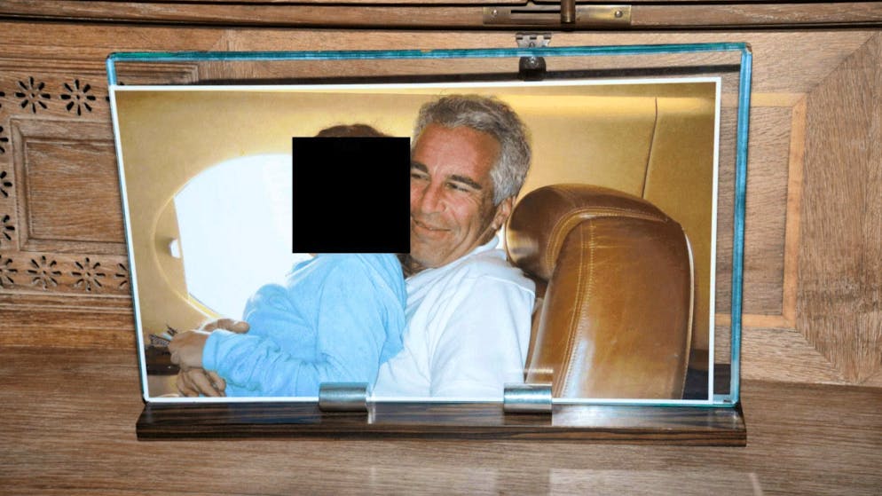 Redacted photo of a woman sitting on Jeffrey Epstein's lap. The framed picture was confiscated during a house search on Little St. James Island.