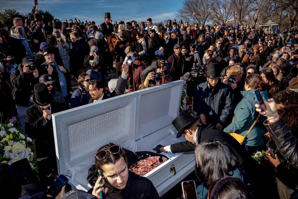 Menschen werfen am Lincoln Memorial in Washington Pennys in einen weissen Sarg.