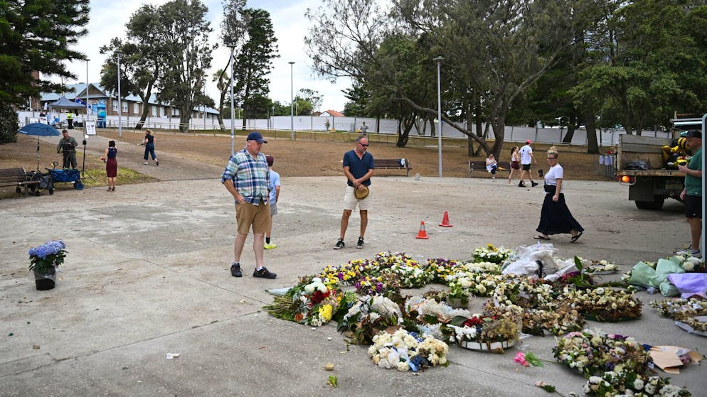 Mitarbeiter der Stadt räumen am Montag am Bondi Beach Blumengaben für die Opfer der Terrorattacke auf. 