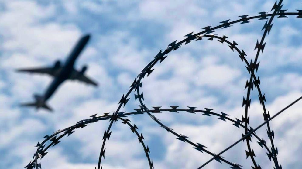 ARCHIVE - An airplane takes off from BER Airport behind a fence with barbed wire. Photo: Sebastian Gollnow/dpa