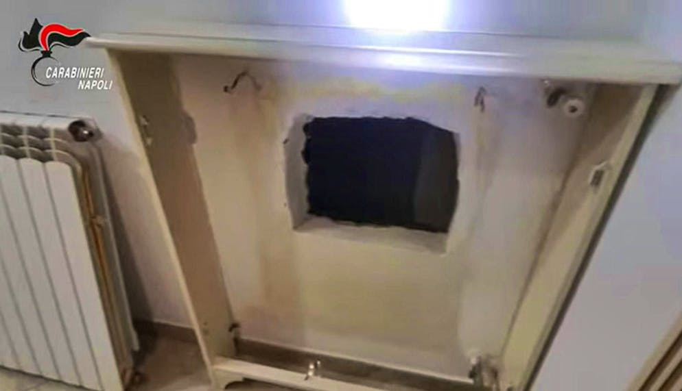 Wanted mafia boss caught in Naples wall hideout - Gallery. The wanted boss of a Camorra clan was hiding behind this hole in the wall. (Handout) 