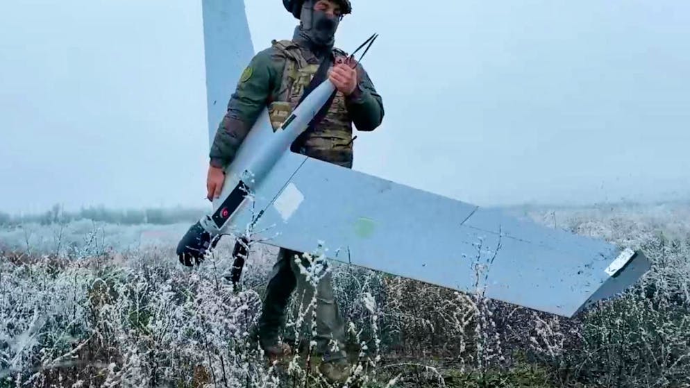 HANDOUT - Ein russischer Soldat trägt eine Drohne zum Start für einen Einsatz in der Ukraine. Foto: Uncredited/ussian Defense Ministry Press Service via AP/dpa - ACHTUNG: Nur zur redaktionellen Verwendung und nur mit vollständiger Nennung des vorstehenden Credits