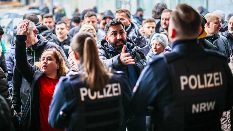 dpatopbilder - Aufgebrachte Kunden diskutieren vor der Sparkassenfiliale in Buer mit Polizeibeamten nach der Räumung des Vorraums der Filiale. Foto: Christoph Reichwein/dpa - ACHTUNG: Nur zur redaktionellen Verwendung im Zusammenhang mit der aktuellen Berichterstattung und nur mit vollständiger Nennung des vorstehenden Credits