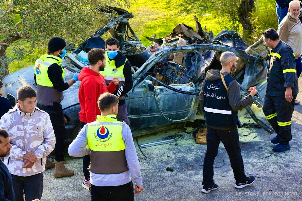 Lebanese rescue workers examine a car that was hit by an Israeli drone in Aatqanit, southern Lebanon, on December 22, 2025. According to the Lebanese news agency, three people were killed.